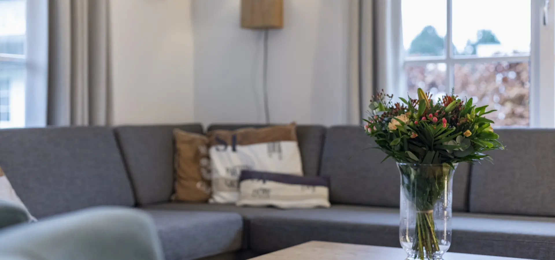 bank in woonkamer met bos bloemen